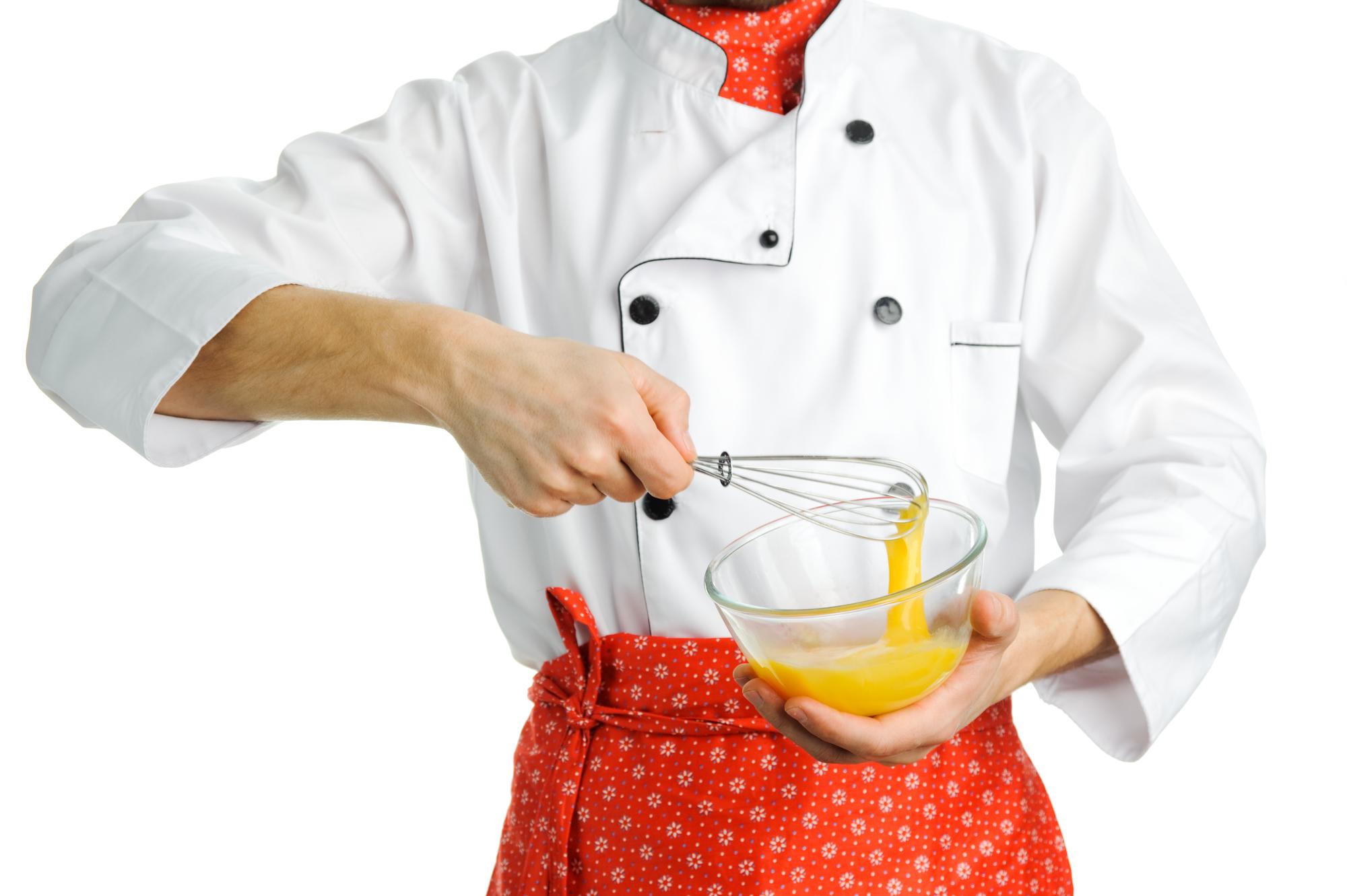 Chef demonstrating plating technique in bright kitchen