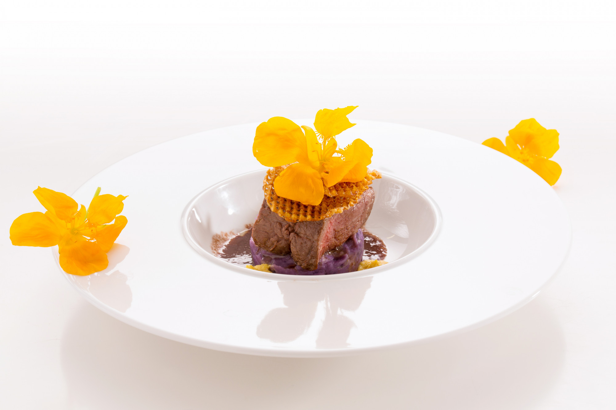 Plated dessert with gold leaf and edible flowers